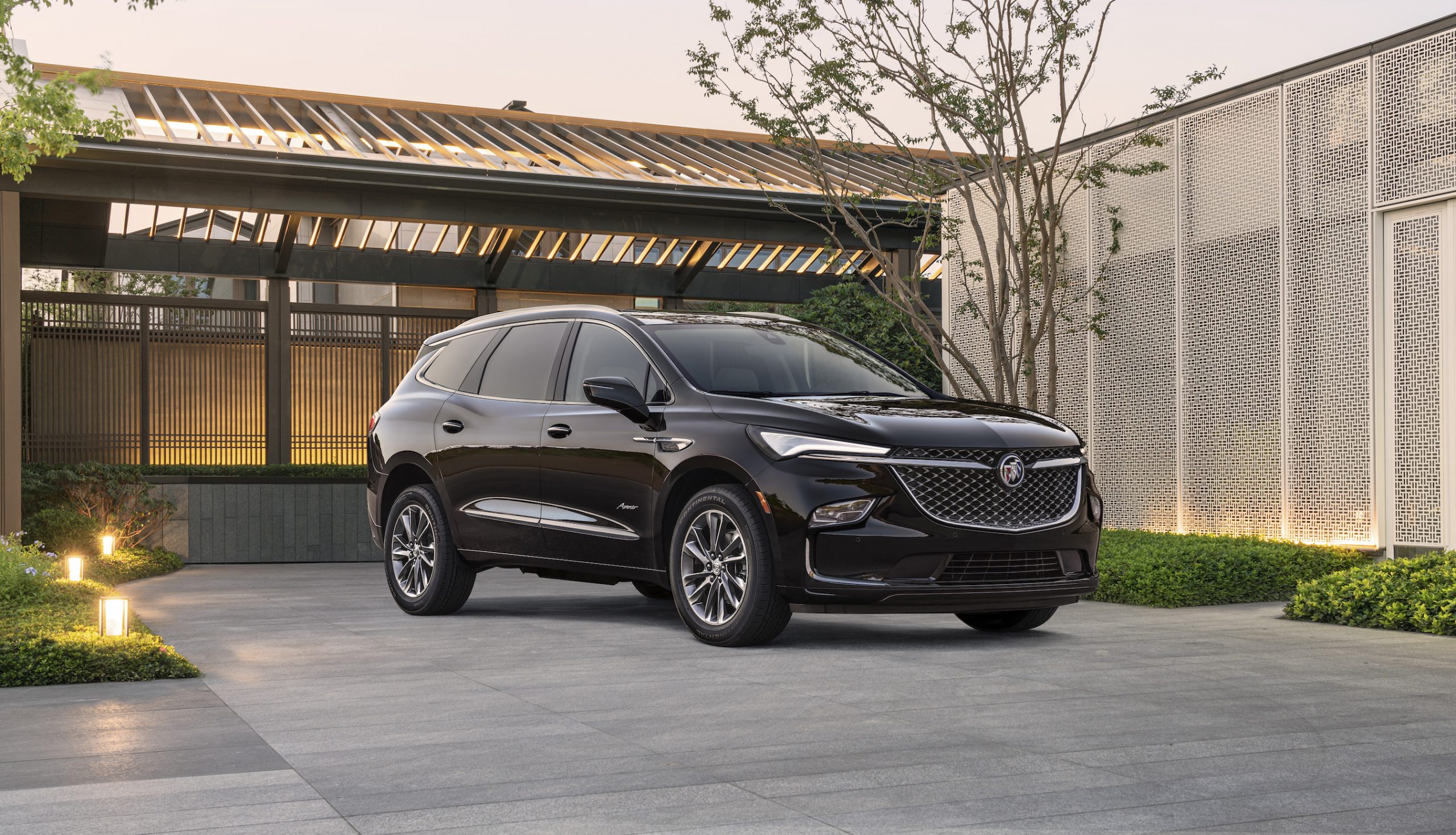 The 2022 Buick Enclave Avenir in black parked in front of a modern home