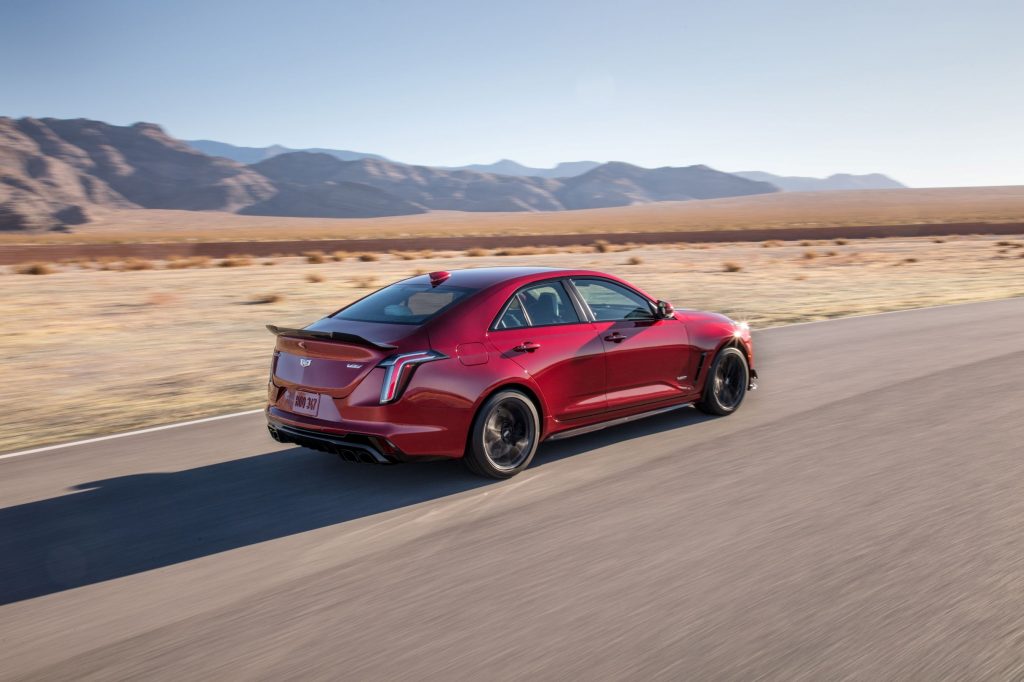 The rear 3/4 view of a red 2022 Cadillac CT4-V Blackwing on a racetrack