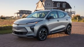 A silver 2022 Chevrolet Bolt EUV by a beach house at sunset