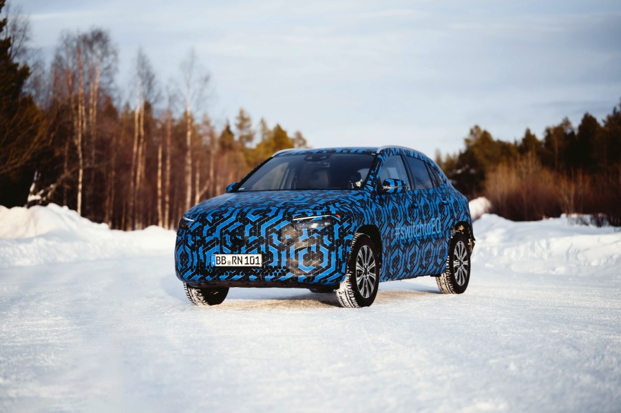 A camo-wrapped 2022 Mercedes-Benz EQA during winter testing on a snow-covered road