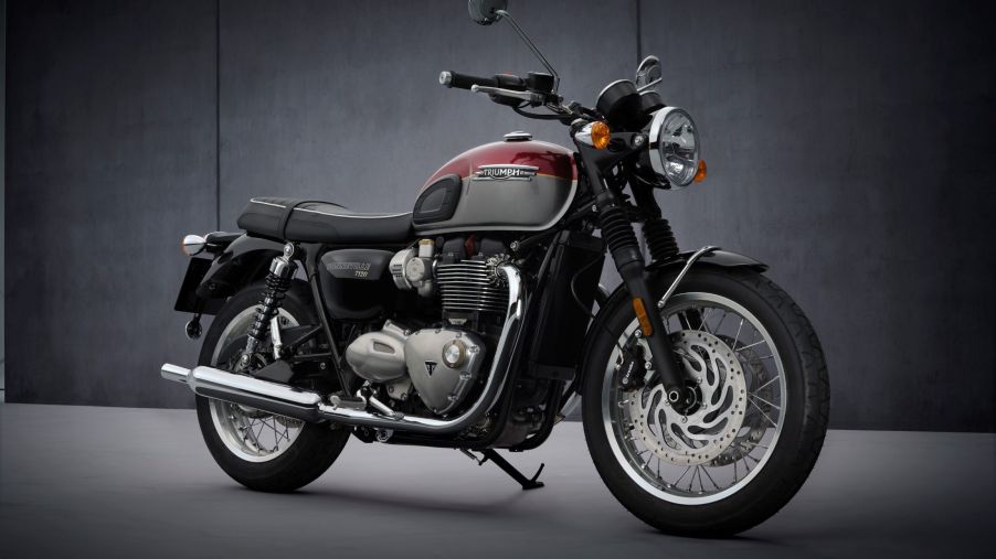 A red-and-silver 2022 Triumph Bonneville T120 in front of a gray background