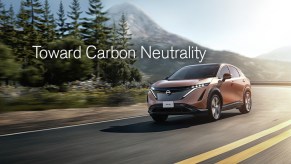A red Nissan SUV driving down a road with a text block above it that reads "toward carbon neutrality"