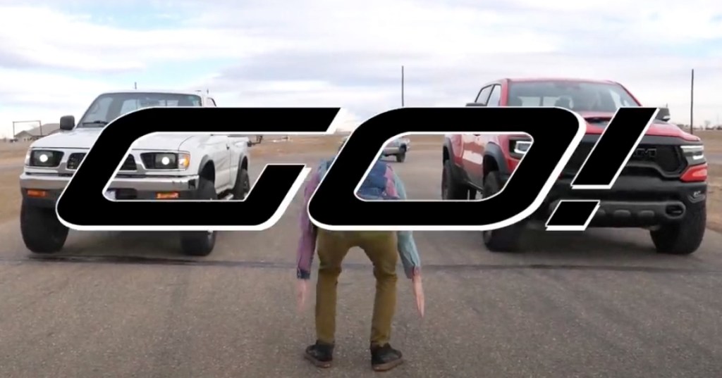 first-gen toyota tacoma pickup truck and the 2021 Ram 1500 TRX about to take off in a drag race