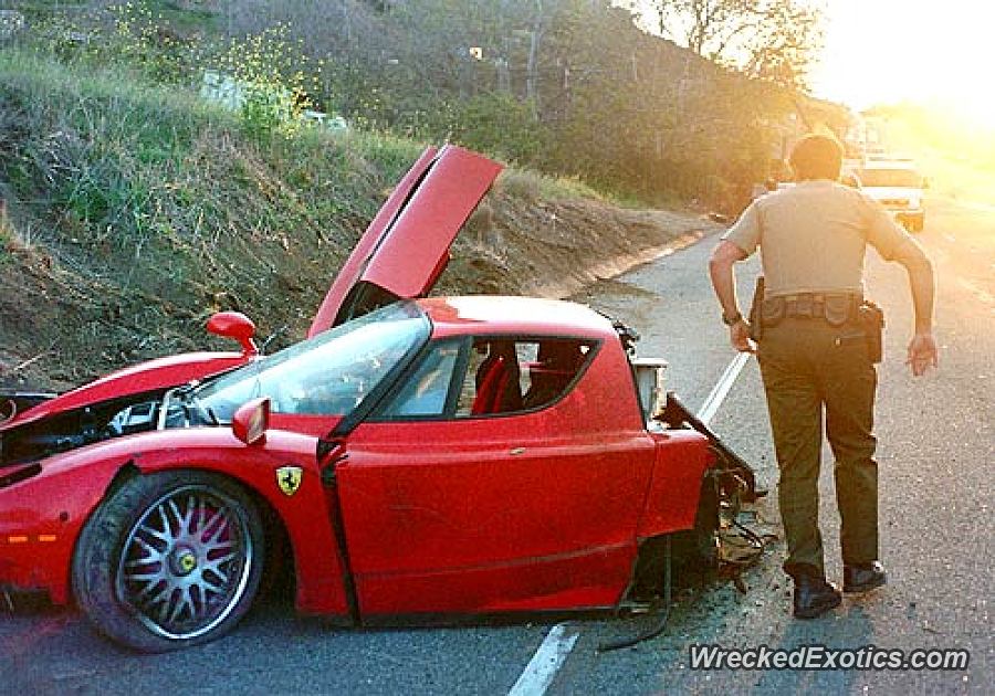 An image of a crashed Ferrari Enzo on the side of the road.