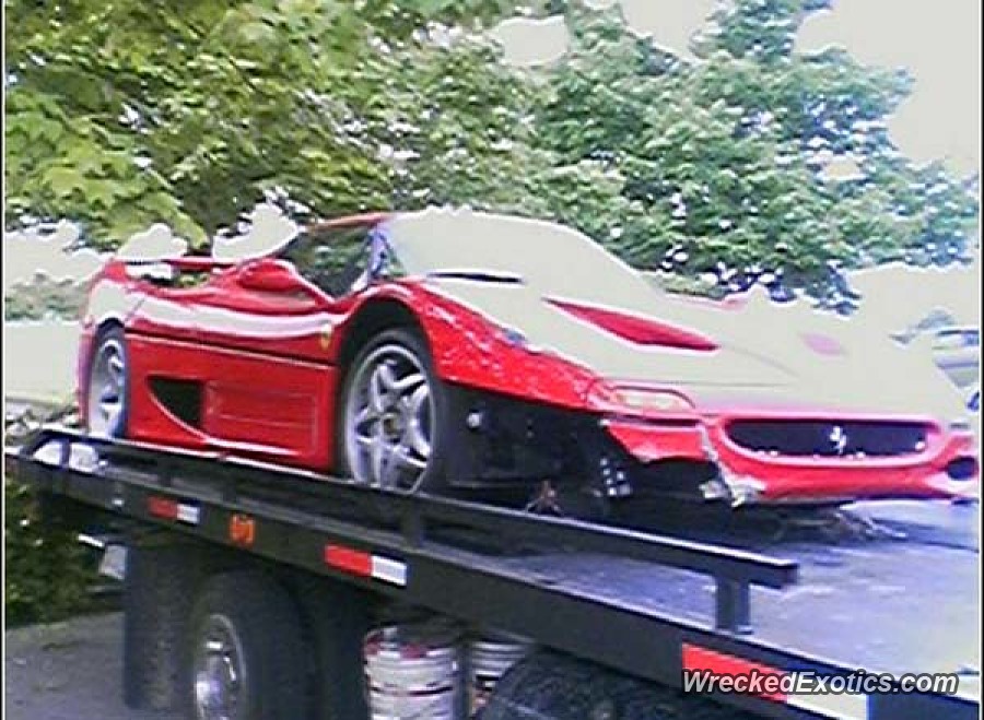 An image of a crashed Ferrari F50 on the back of a flatbed tow truck.