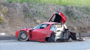 An image of a crashed Ferrari Enzo on the side of the road.