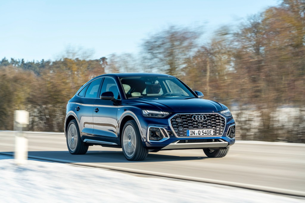 An Audi Q5 55 TFSI e quattro in Navarra blue driving down a wintery road