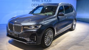 A blue BMW X7 on display at an auto show