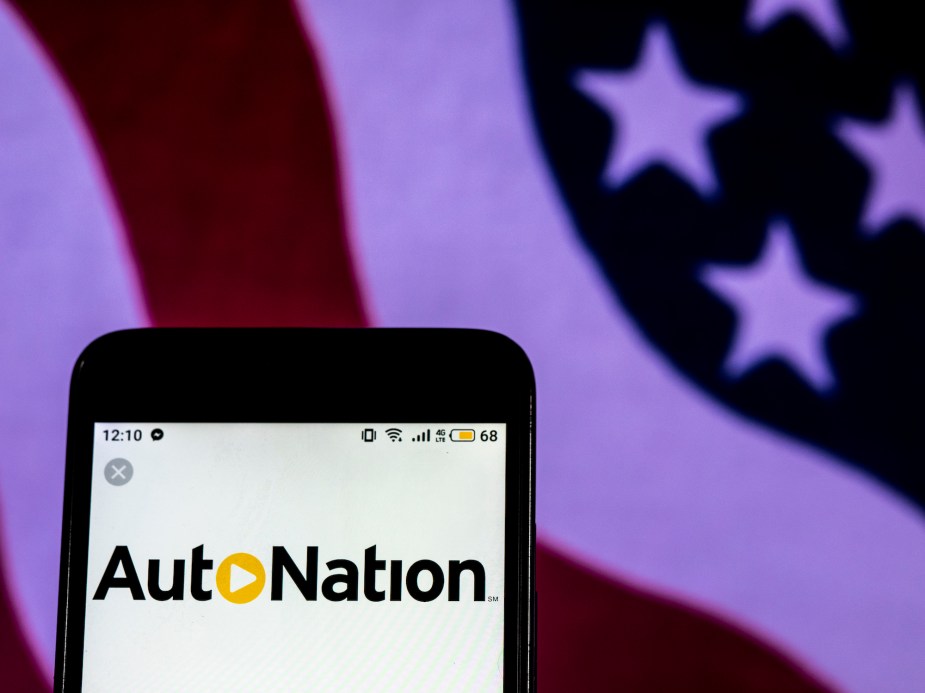 The AutoNation logo displayed on a smartphone with an American flag in the background