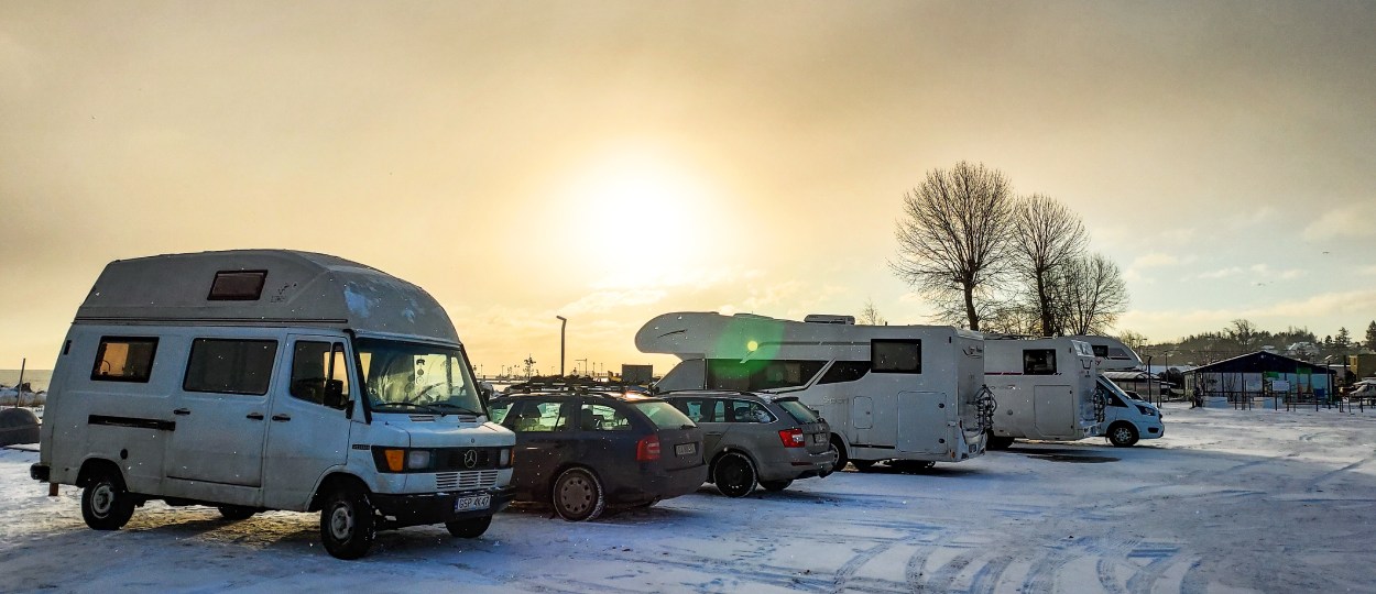 Camper vans and motorhomes parked in a snowy parking lot
