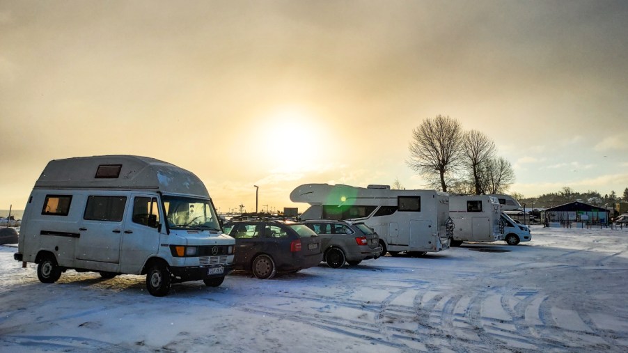 Camper vans and motorhomes parked in a snowy parking lot