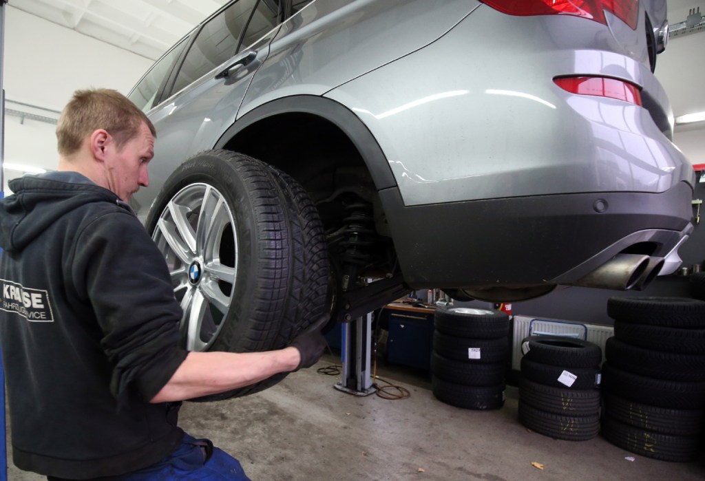 An auto mechanic changes the tires on a car