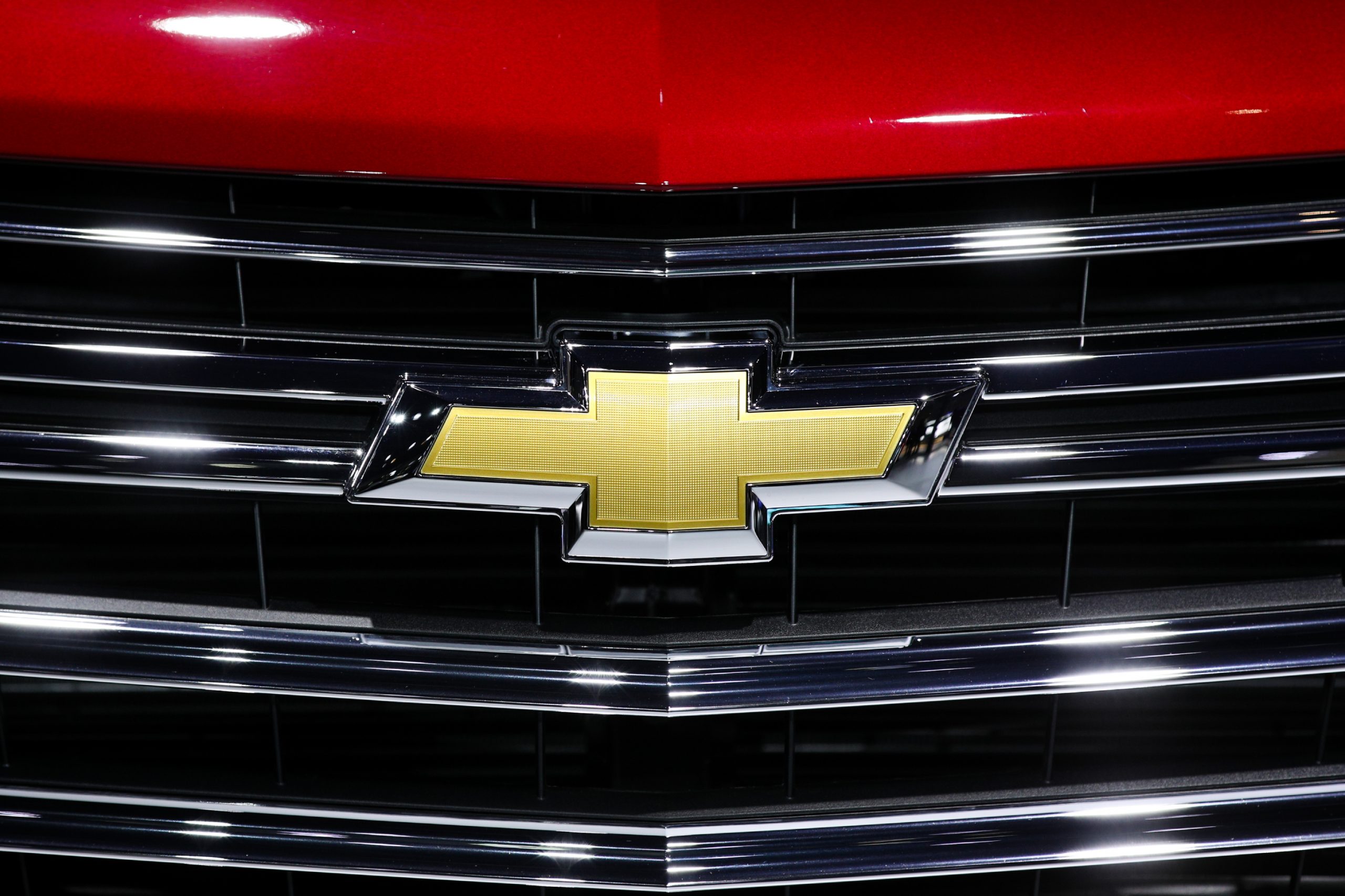 A close-up of Chevy's bow-tie logo on the grille of a car