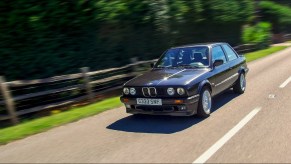 A dark-blue E30 BMW 320is on the road