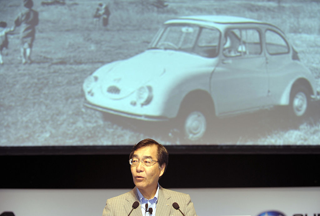 Fuji Heavy Industries president and CEO Ikuo Mori delivers a speech in front of an image of the Subaru 360