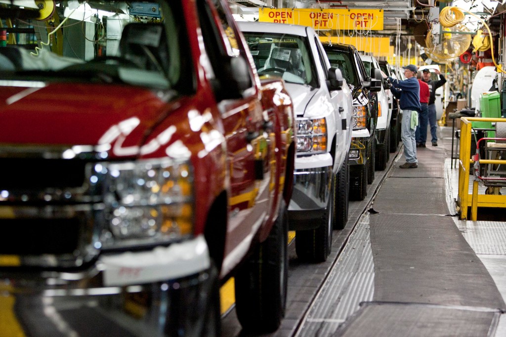 Chevy Silverado and GMC Sierra trucks being inspected on the assembly line