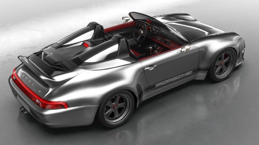 The overhead rear 3/4 view of a silver Gunther Werks 993 911 Speedster with a red interior