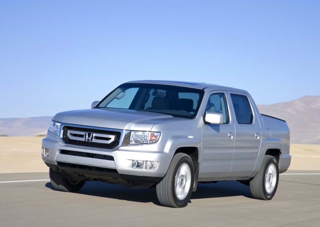 a silver 2009 honda ridgeline pickup truck driving in the sand 