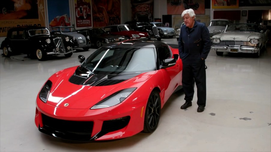 Jay Leno with a red 2020 Lotus Evora GT in his garage