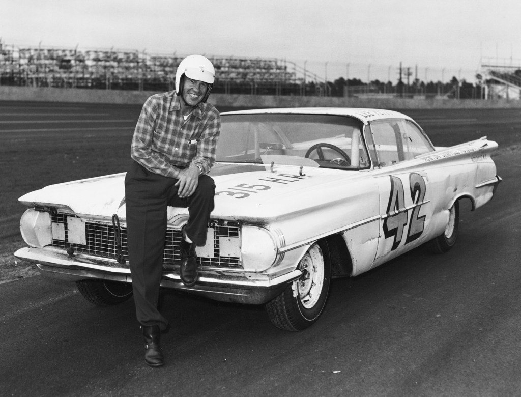 Lee Petty sitting on the hood of his No. 42 1959 Oldsmobile Super 88 before the start of the first Daytona 500