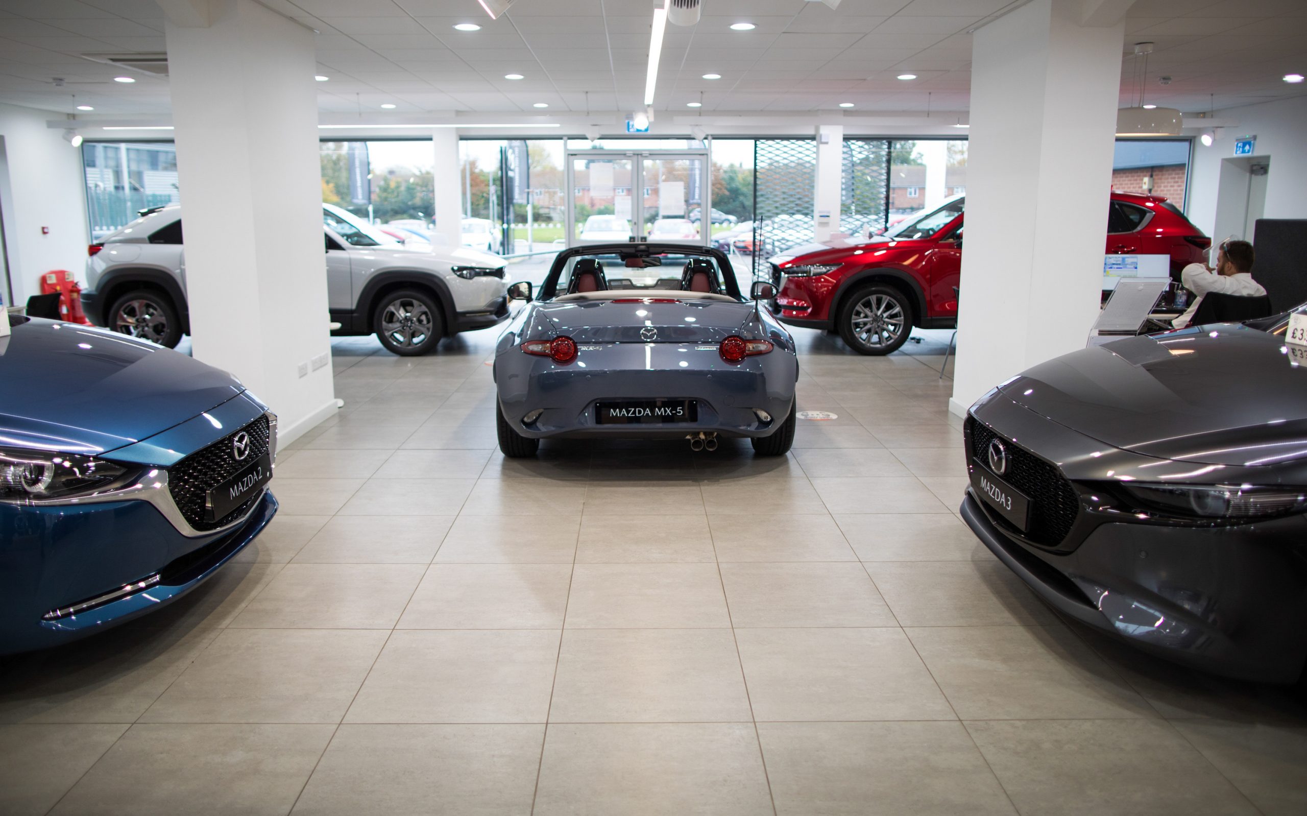 Automobiles manufactured by Mazda Motor Corp., including a MX-5, centre, in the showroom of a dealership