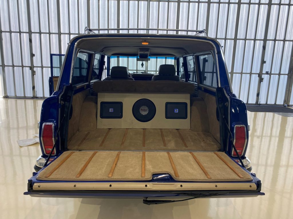 The view of a modified 1991 Jeep Grand Wagoneer's interior from the open rear tailgate