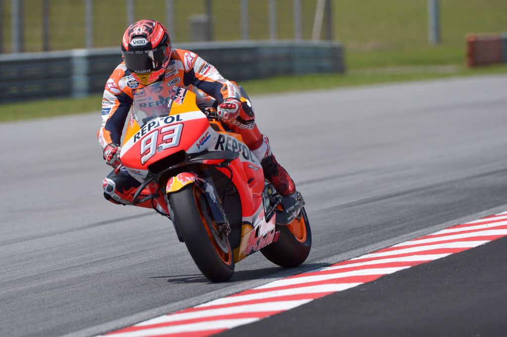 MotoGP rider Marc Marquez starts to countersteer his orange-and-red Repsol Honda motorcycle into a corner