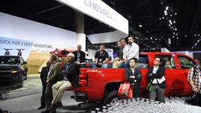 Attendees sit in the bed of a 2015 Silverado 2500 HD as they listen to the Chevrolet press conference, at the Los Angeles Auto Show