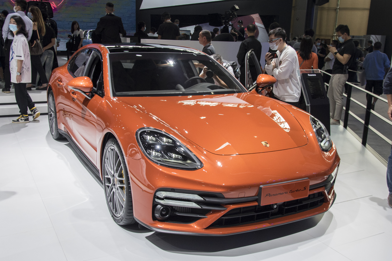 An orange Porsche Panamera Turbo S on display at an auto show