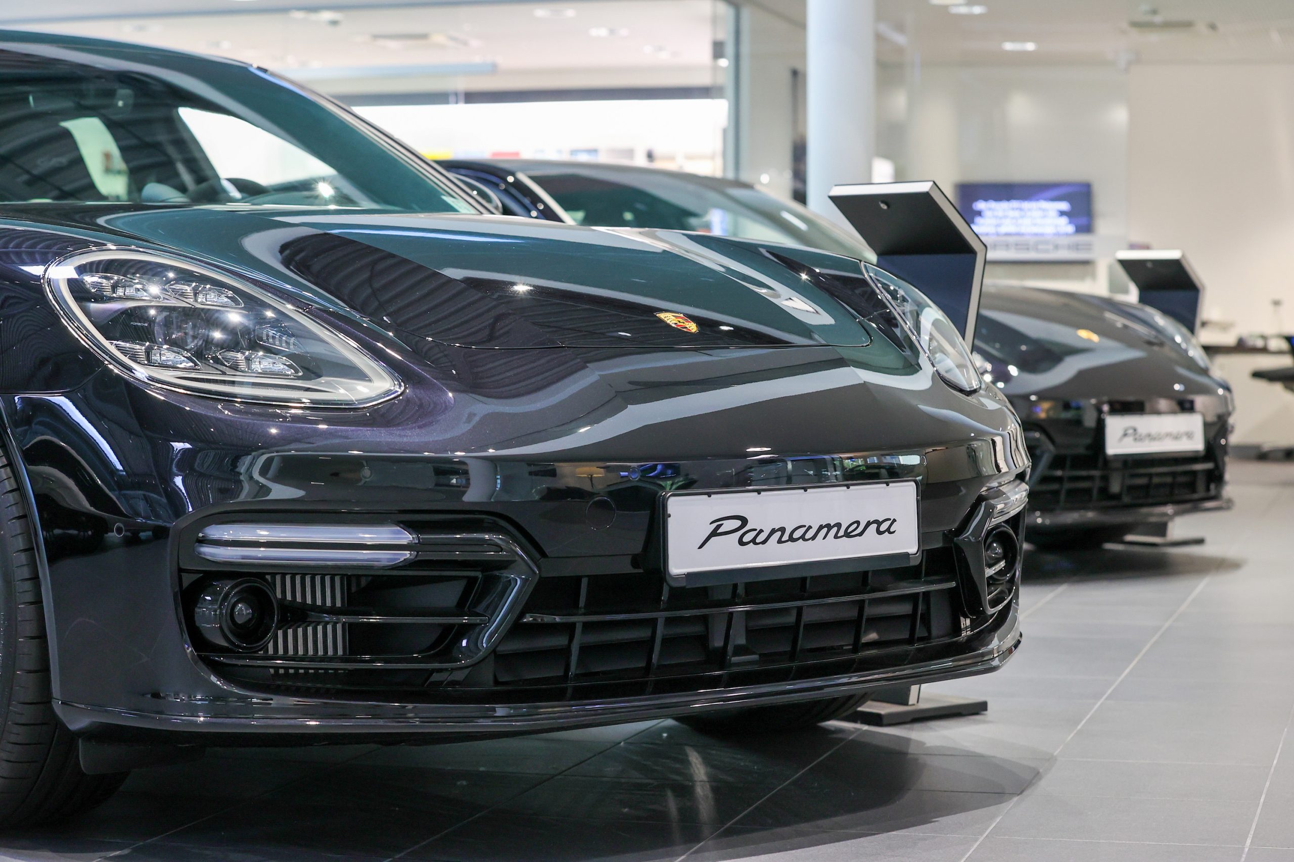 Panamera luxury automobiles, manufactured by Porsche SE, sit on display in the showroom at the Porsche Automobil Holding SE center in Hamburg, Germany