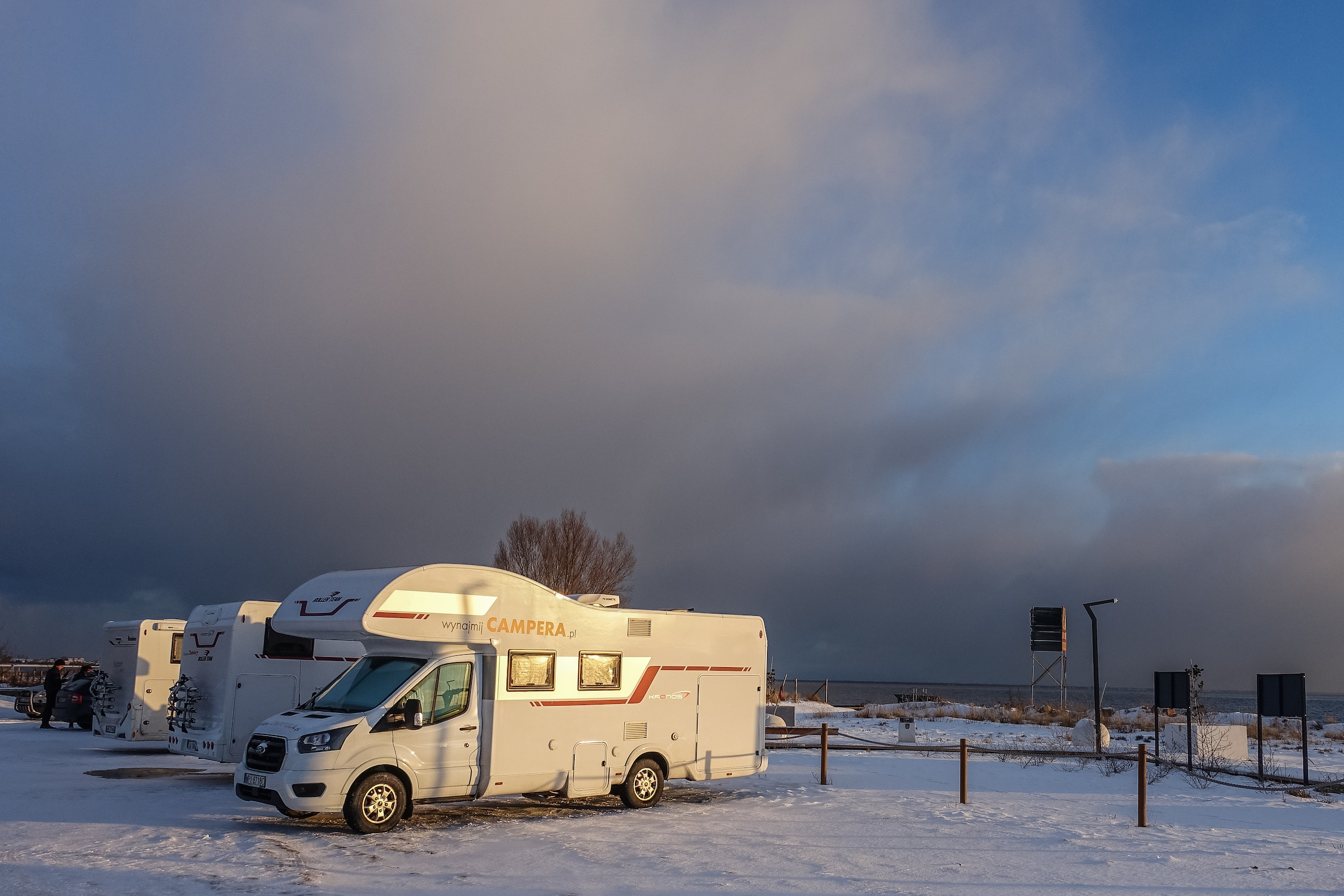 Motorhome RVs parked by the sea are seen in Mechelinki, Poland, on 6 February 2021