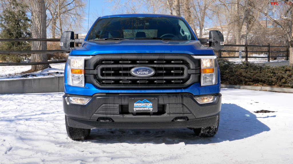 An image of a blue Ford F-150 parked outside on the snow.