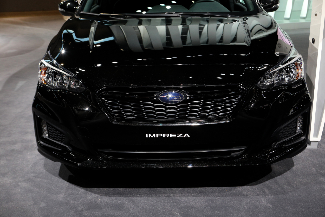 A black Subaru Impreza on display at an auto show