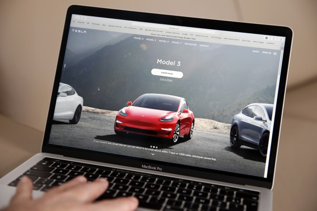 A person browsing Tesla Model 3 cars on the company's website