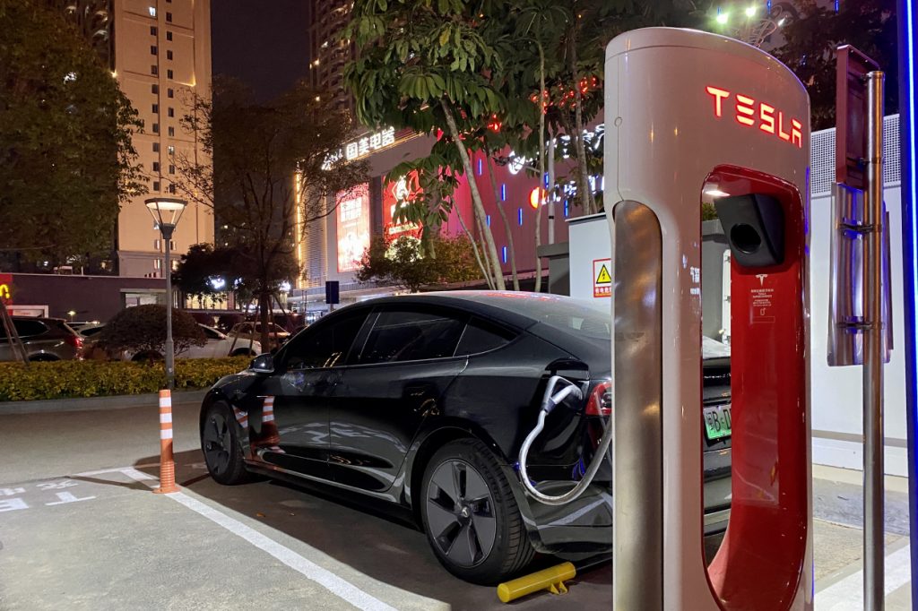 A Tesla car plugged into a charging station