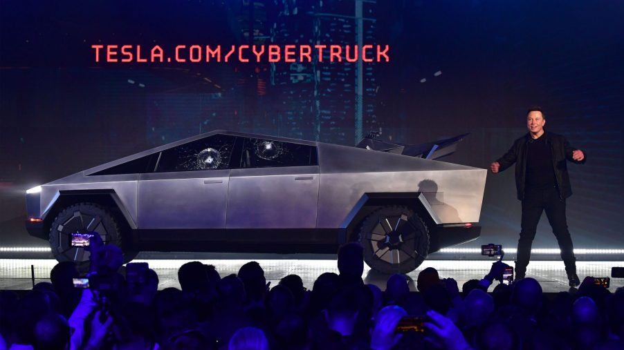 Tesla co-founder and CEO Elon Musk on stage with the newly unveiled all-electric battery-powered Tesla Cybertruck with broken glass on windows following a demonstation that did not quite go as planned