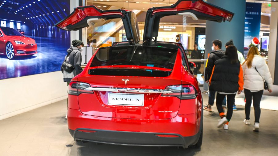 Customers watch a Model X vehicle at a Tesla flagship store