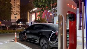 An electric vehicle charges at a Tesla charging station on February 2, 2021