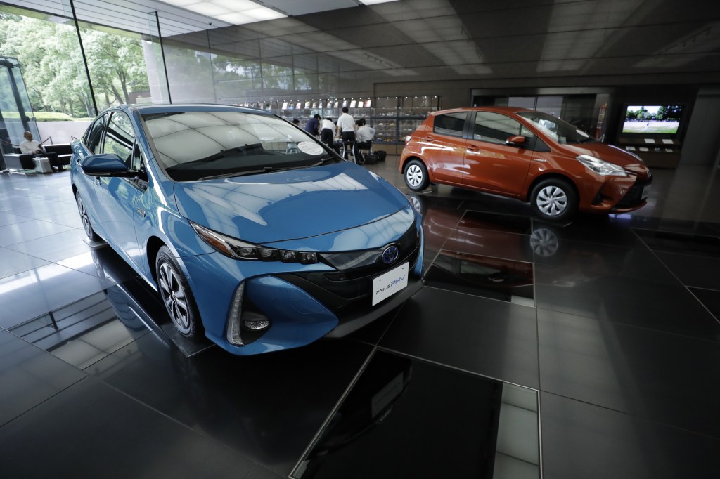 A blue Toyota Prius Prime and another red Toyota on display in a showroom