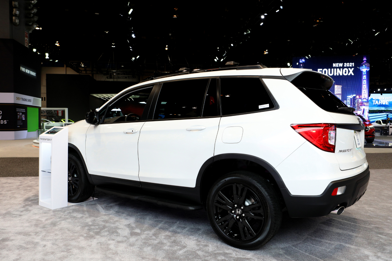 A white Honda Passport on display at an auto show