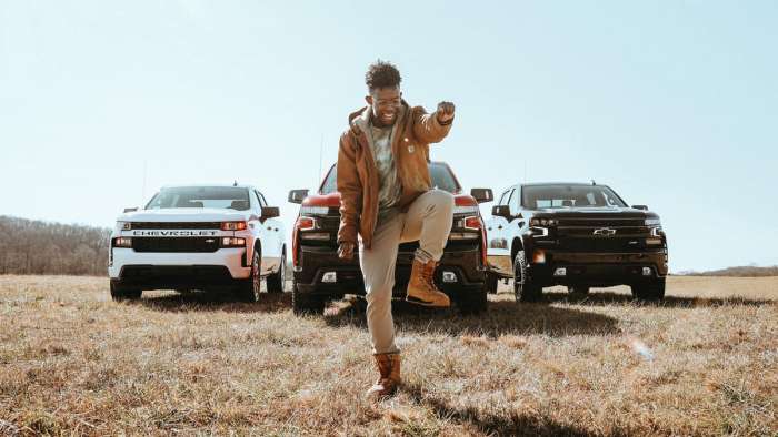 Artist named BRELAND dancing in front of three 2021 Chevy Silverado models 