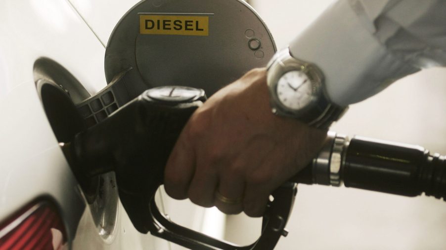 a man pumps diesel fuel into a car