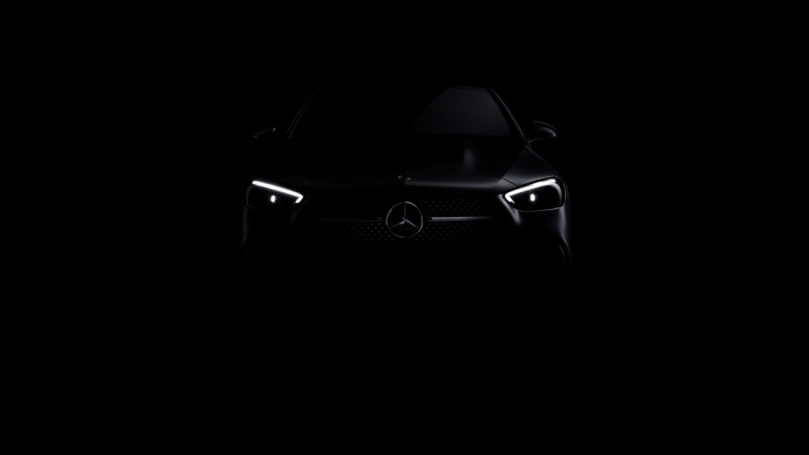 The headlights of a 2022 Mercedes-Benz C-Class peaking through the darkness