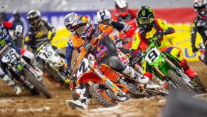 supercross riders competing for the hole shot as they turn around the first corner.