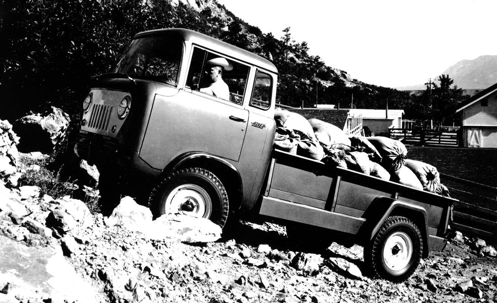 A 1957 Jeep FC crawling over the terrain 