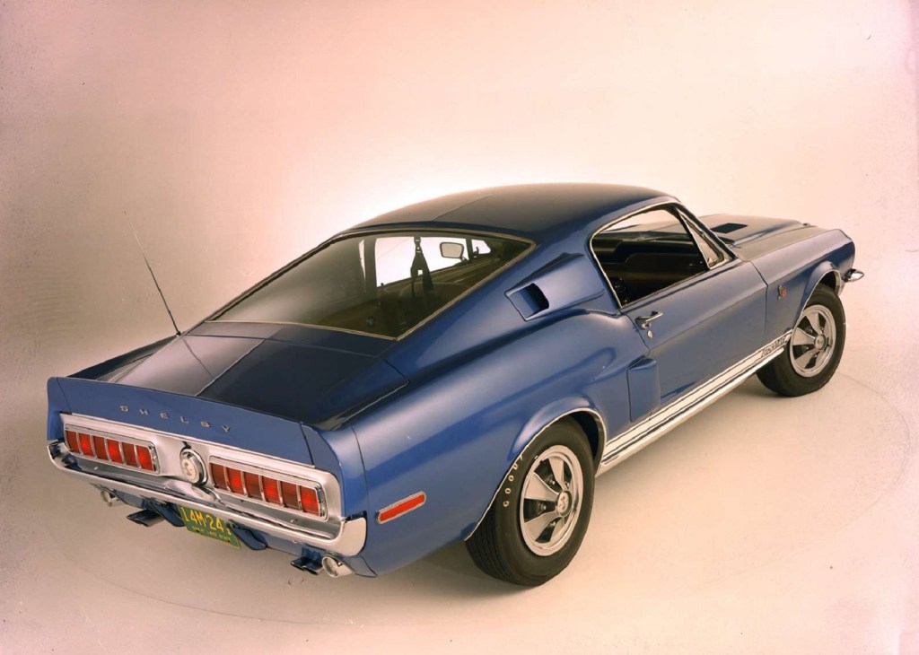The rear 3/4 view of a blue-and-white 1968 Shelby GT500KR Mustang