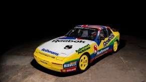 A multi-colored Rothmans-liveried 1988 Porsche 911 Turbo Cup in a warehouse