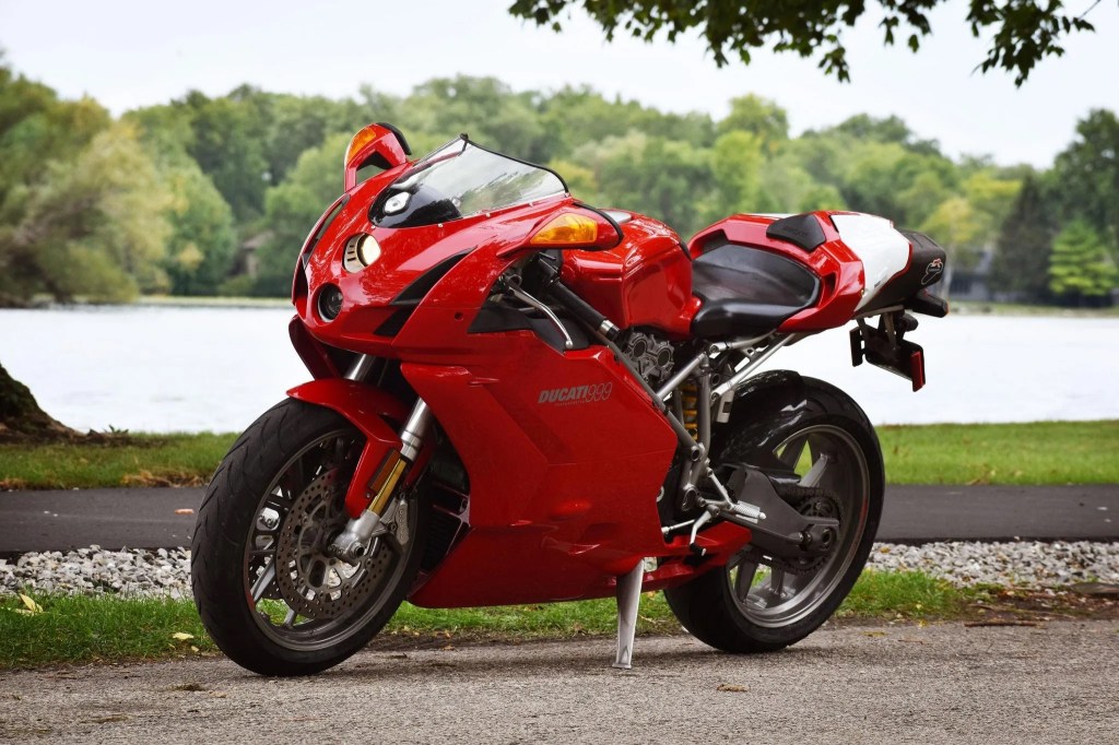 A red 2003 Ducati 999 by a forest lake