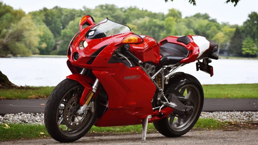 A red 2003 Ducati 999 by a forest lake