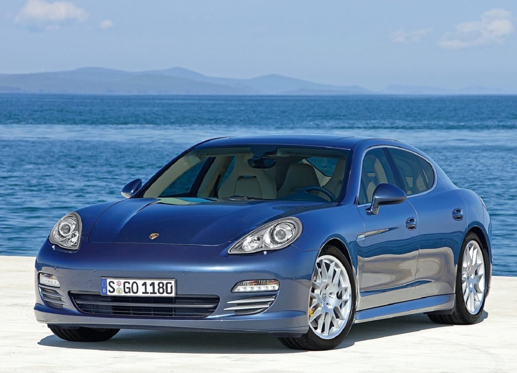 A blue 2010 Porsche Panamera 4S parked on a pier by the ocean